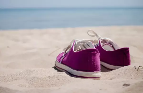 Schuhe im Sand /  Girl's sneakers on the beach