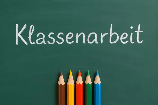 Schulische Leistungsmessung mit Buntstiften an der Tafel