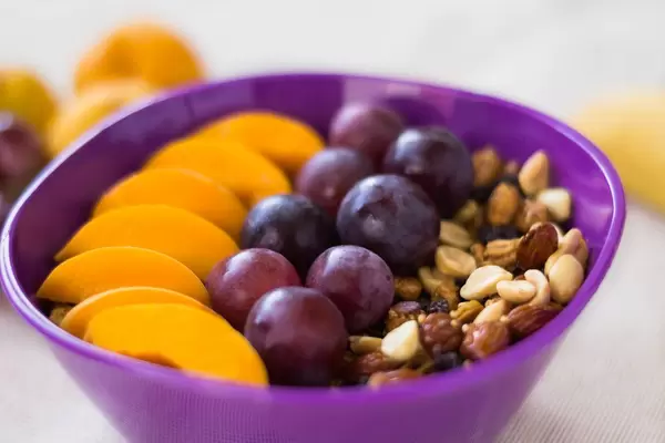 Schüssel Granola mit Trauben und Pfirsichscheiben