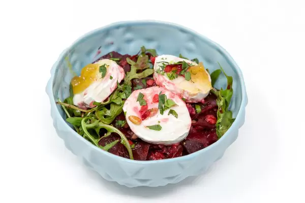 Schüssel mit Salat aus roter Bete, Apfel, ganzen Rucolablättern und Ziegenkäse