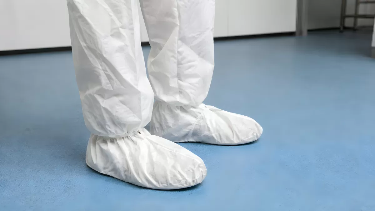 Schutzanzug mit weißen Überschuhen im Reinraum