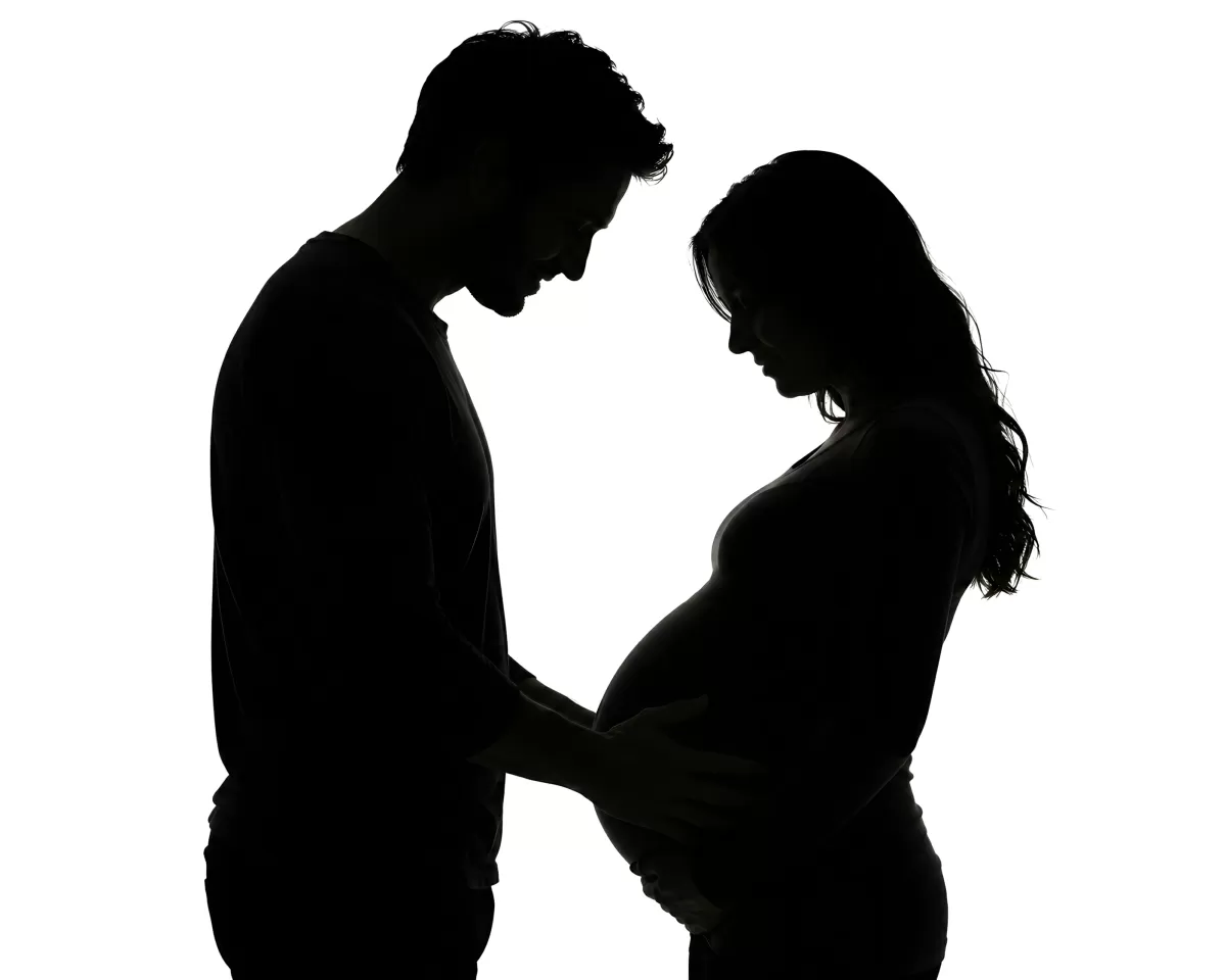 Schwangere Frau mit Partner als stimmungsvolles Silhouettenbild