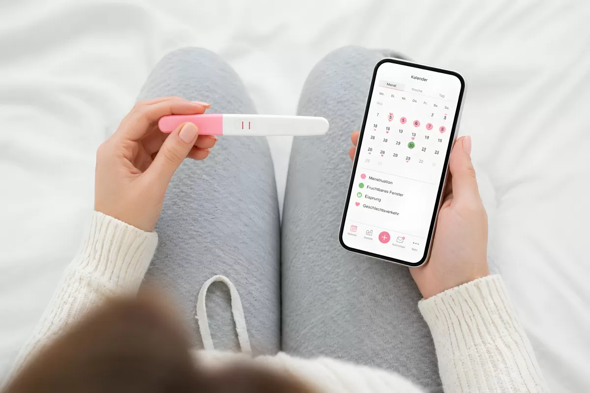 Schwangerschaftstest mit Zyklus-App auf Smartphone