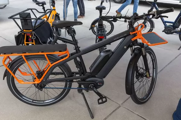 Schwarz-oranges gepäckraumoptimiertes E-Bike von Riese & Müller, als Ausstellungsstück für nachhaltige umweltfreundliche Elektrofahrzeuge