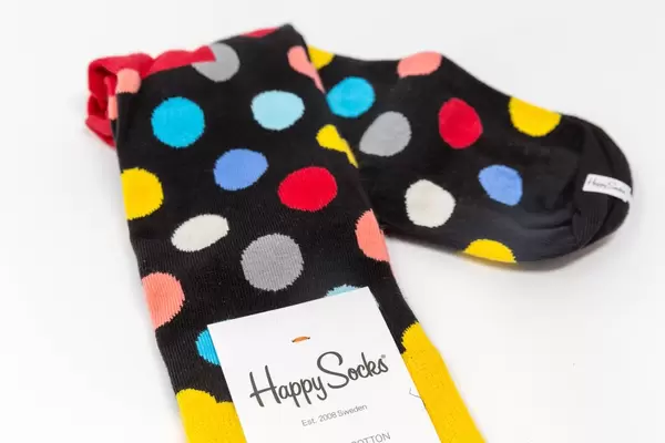 Schwarze Baumwollsocken mit bunten Punkten auf weißem Hintergrund