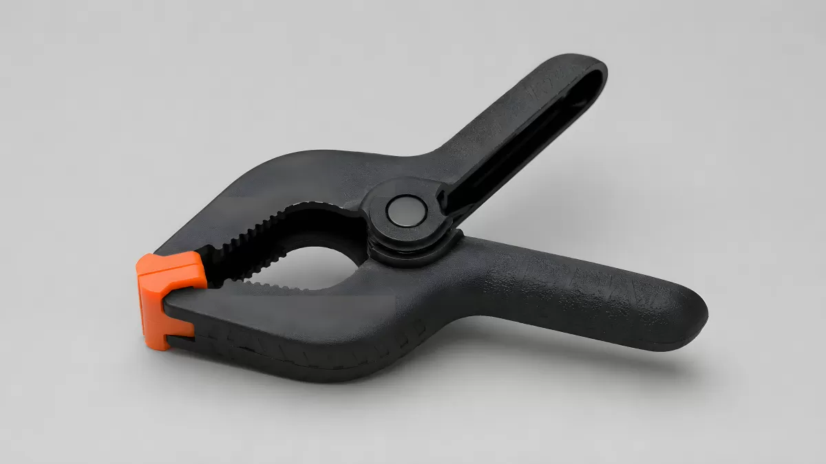 Schwarze Federklemme mit orangefarbenem Anschlag