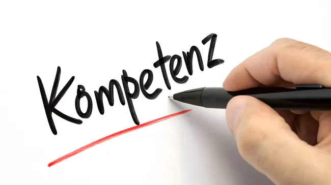 Schwarze Handschrift 'Kompetenz' mit roter Markierung