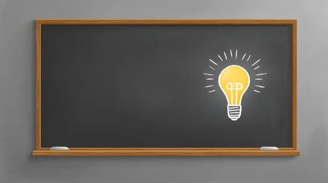 Schwarze Kreidetafel mit Glühbirne als Ideensymbol