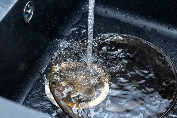 Schwarze Spüle mit fließendem Wasser