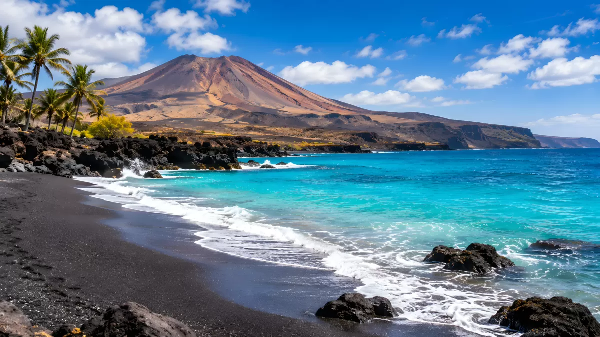 Schwarzer Vulkanstrand mit türkisblauem Meer und Vulkan — Bild kostenlos herunterladen