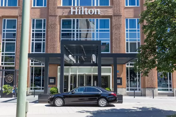 Schwarzes Auto steht vor dem Eingang des Hilton Hotels in München