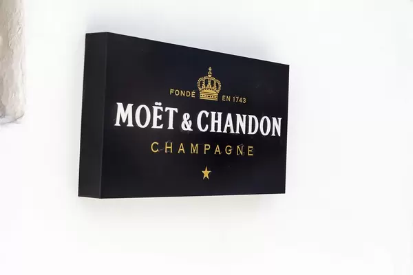 Schwarzes Moët & Chandon Champagne Schild auf weißer Wand auf Mykonos, Griechenland