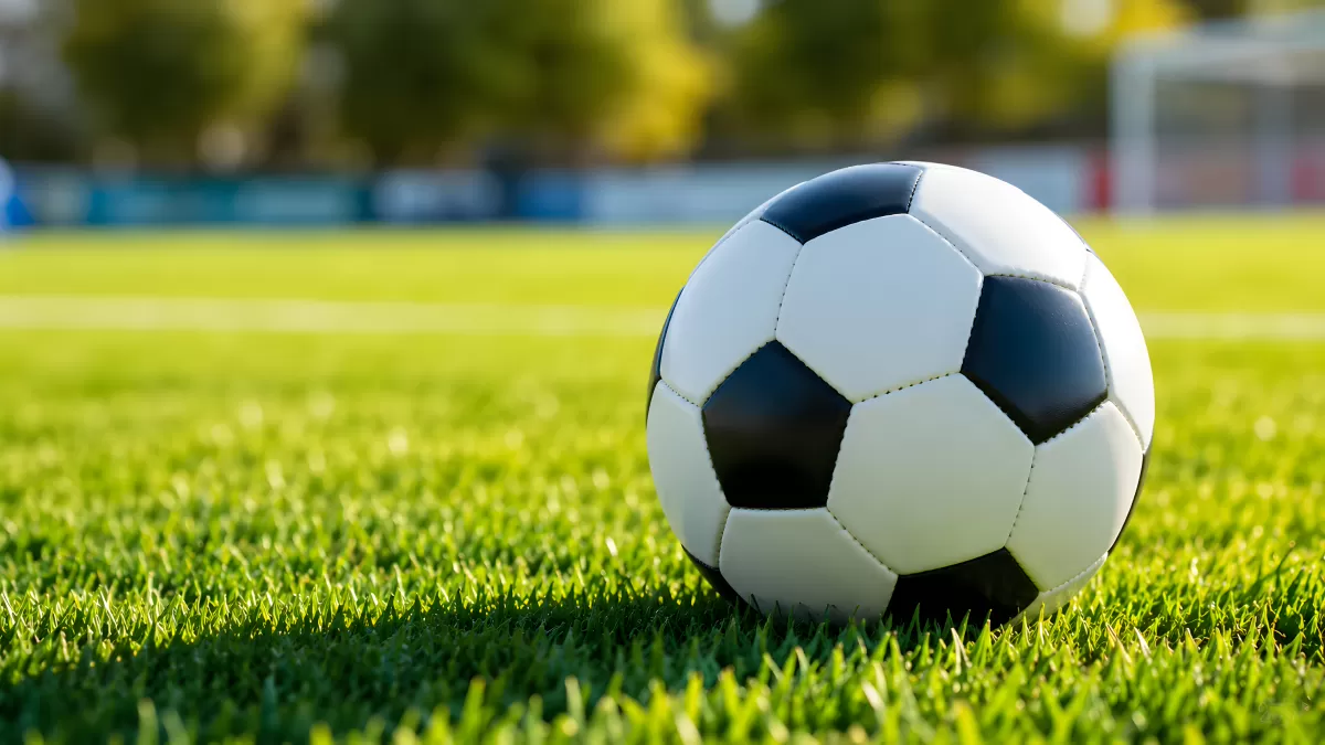 Schwarzweißer Fußball auf grünem Rasen im Stadion