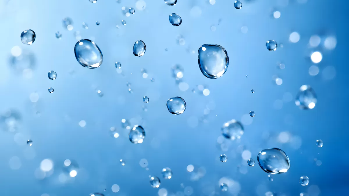 Schwebende Wassertropfen vor blauem Hintergrund