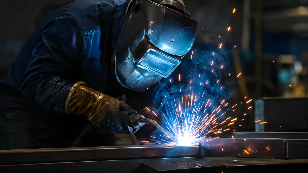 Schweißer bei der Arbeit mit Funkenflug in der Werkstatt