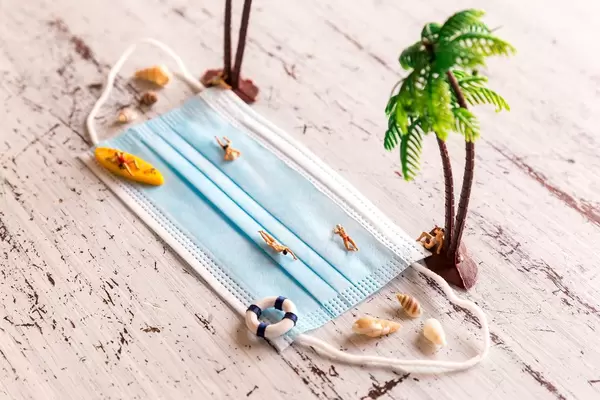 Schwimmen mit Abstand auf Mundschutz. Urlauber im Sommer 2020 halten die Corona-Regeln ein