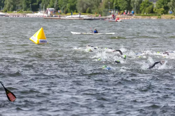 Schwimmer kraulen um eine Boje während des Ironman-Wettbewerbs im See Vesijärvi vor der Küste von Lahti, Finnland