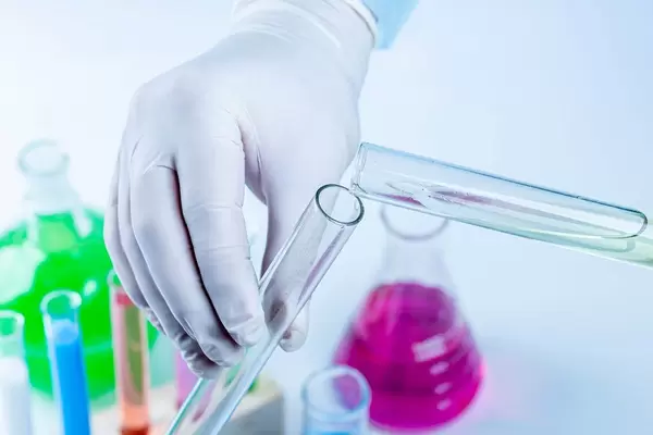 Scientist pouring liquid from a test tube, close up. Chemistry experiment (Flip 2020)