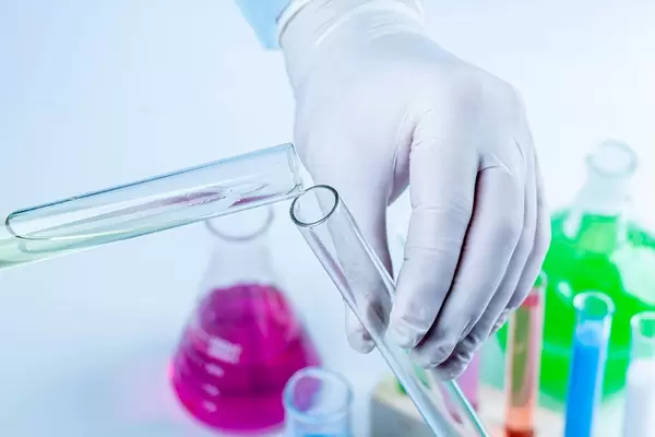 Scientist pouring liquid from a test tube, close up. Chemistry experiment