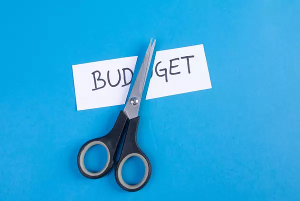 Scissors and two pieces of paper with Budget text