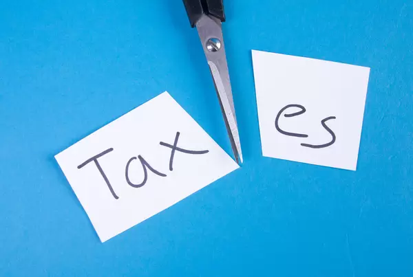 Scissors and two pieces of paper with Taxes text