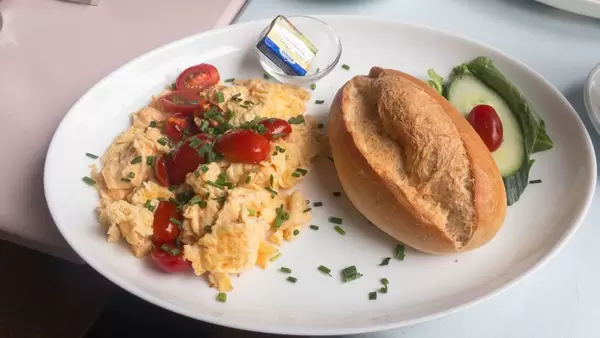 Scrambled eggs, cherry tomato, chives, bread bun and butter