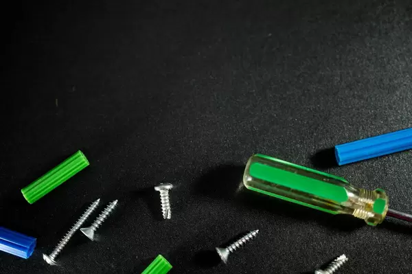 Screws and tools on a black surface