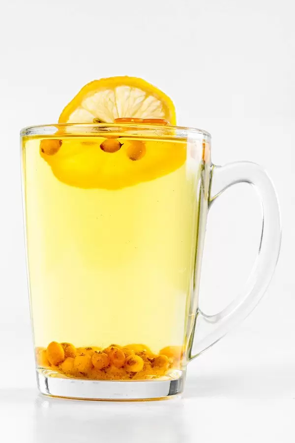 Sea buckthorn tea in a glass cup on a white background