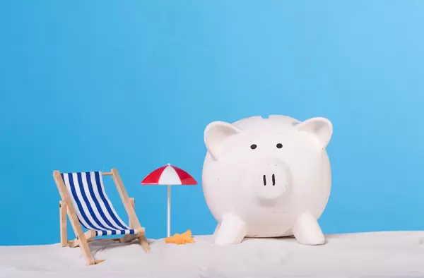 Sea chair with piggy bank on the sandy beach