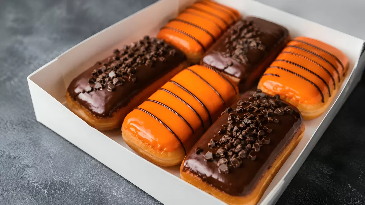 Sechs Eclairs mit Schokoladen- und Orangenglasur in Box