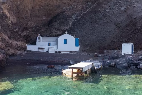 Secret gems: a small white church with blue doors hidden on a beach only reachable by boat