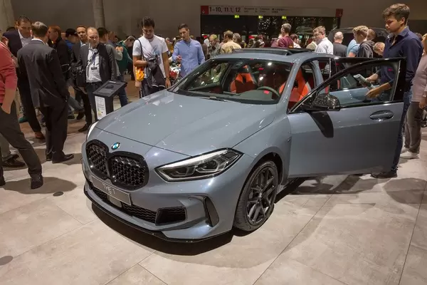 Seitenansicht: Mann steigt in den Sportwagen der BMW 1er Reihe "M135i xDrive" mit Allrad-Antrieb ein