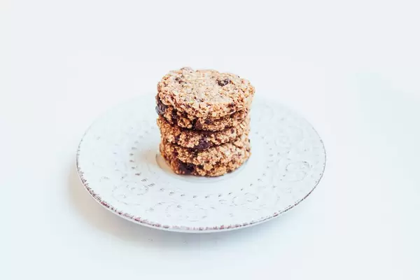 Selbst gemachte Haferkekse mit Schokolade gestapelt auf einem weißen Teller auf weißem Hintergrund