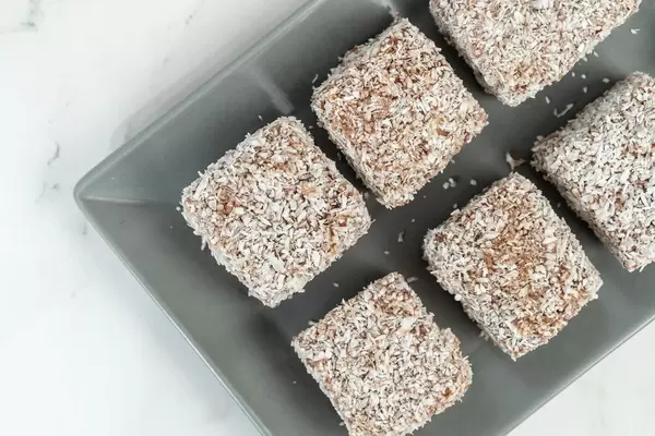 Selbstgebackene, quadratische Kokosnussplätzchen auf einem grauen Teller