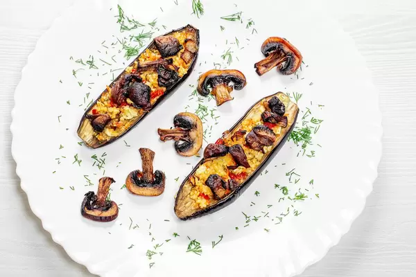 Selbstgebackene und gefüllte Auberginen mit Champignons, Paprika und Dill, auf einem Teller, aus der Sicht von oben