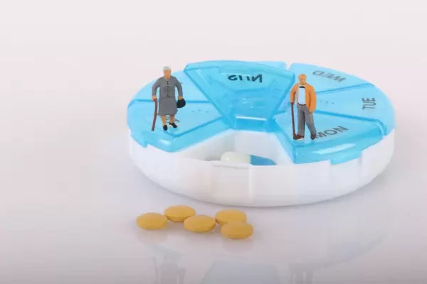 Senior couple with pill reminder box