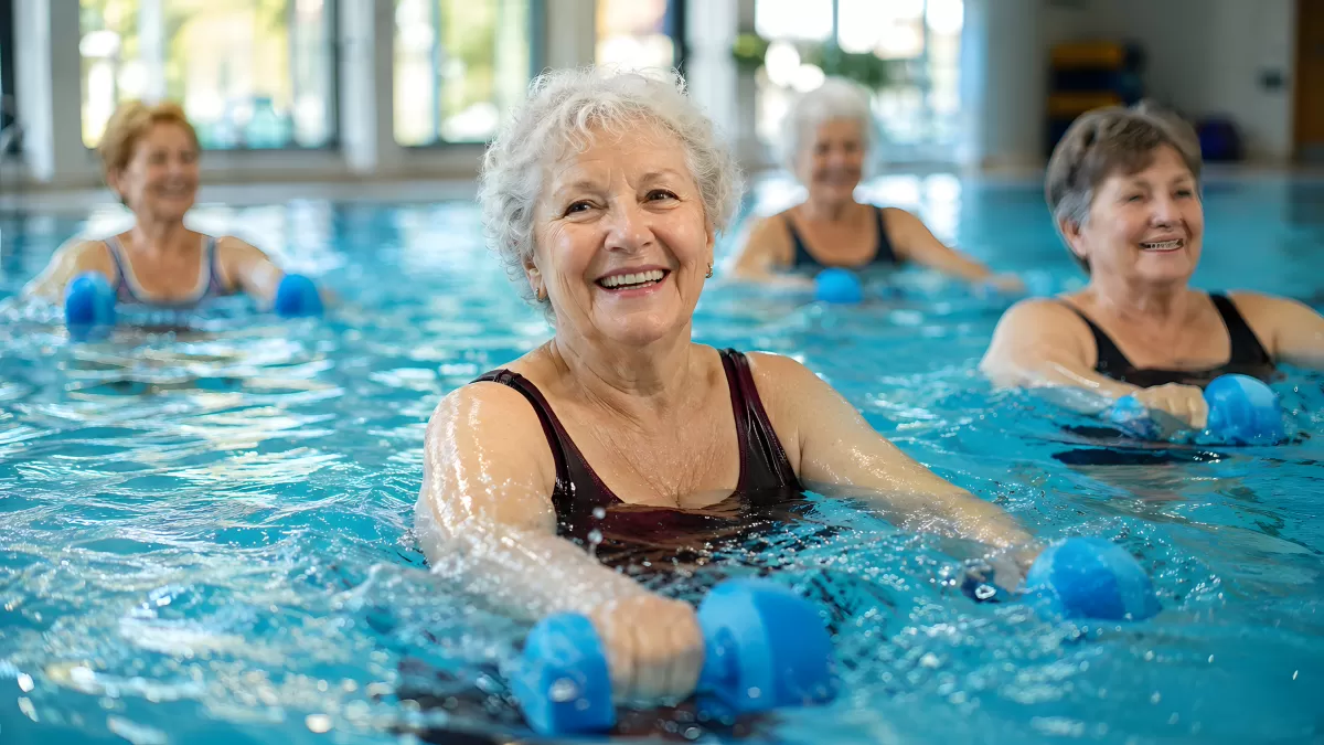 Seniorinnen beim Aqua-Fitness mit Hanteln im Hallenbad