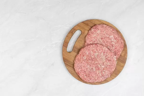 Serbian Pljeskavica on the round wooden board