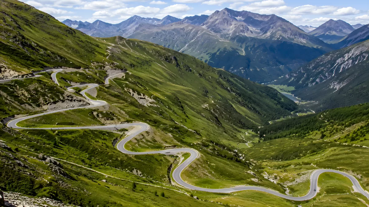 Serpentinenstraße durch grüne Alpentäler im Sommer