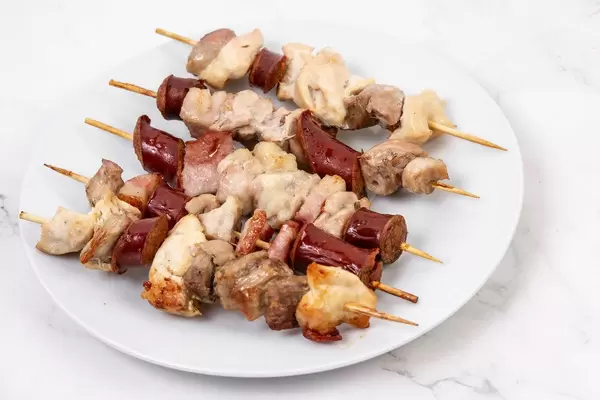 Served sliced Sausage Bacon and Meat on the wooden grill stick (Flip 2019)