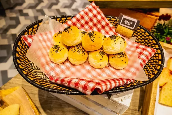 Sesame rolls on wooden basket with table cloth