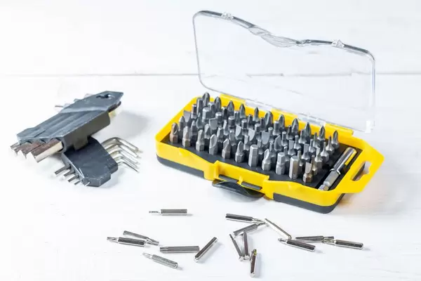 Set aus verschiedenen Schraubendreher-Aufsätzen (Bits) sortiert in Kunststoffbox auf weißem Tisch