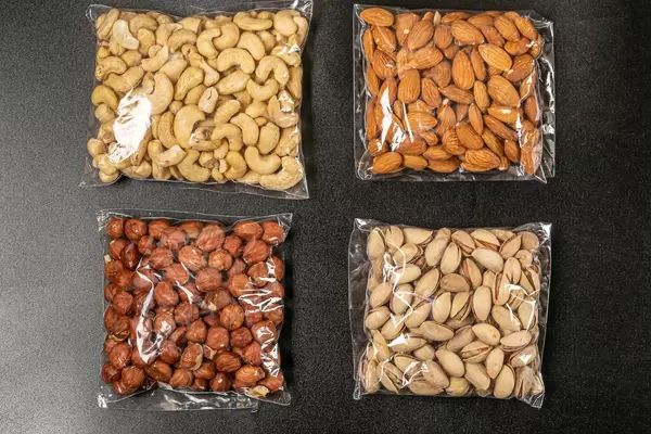 Set of cashew nuts, almonds, hazelnuts and pistachios on a black background