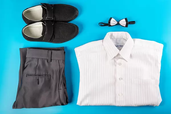 Set of children's men's classic clothes on blue, top view