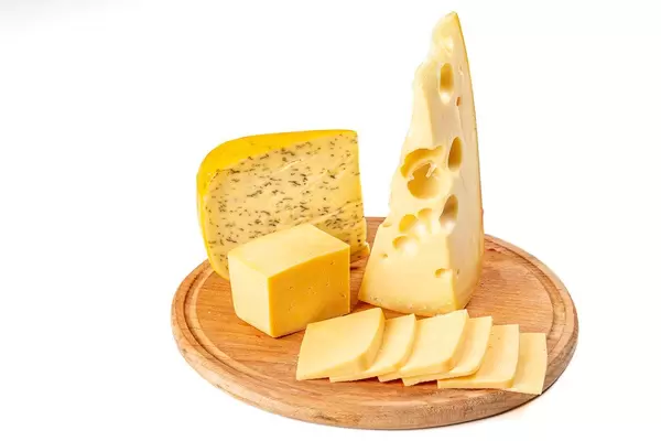 Set of different delicious cheeses on a round wooden kitchen board (Flip 2020)