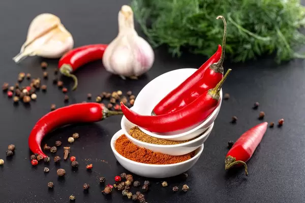 Set of different spices with fresh hot chili on a black background