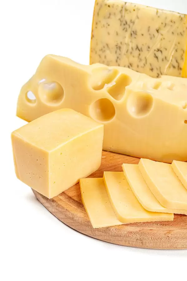Set of different types of cheese on a wooden kitchen board, close-up