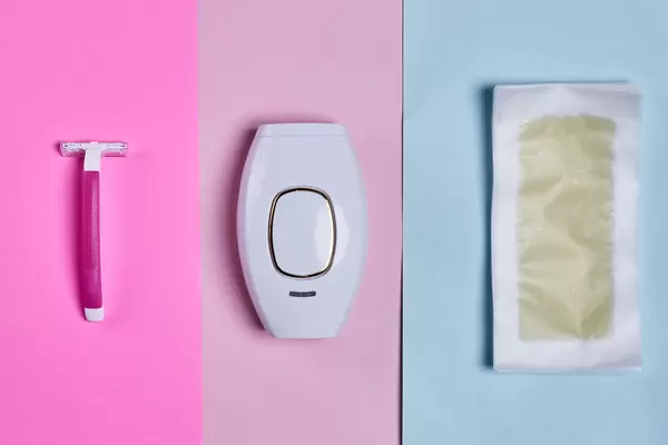 Set of hair removal tools. Wax strips, modern laser epilator and razor on a colored background