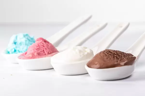 Set of ice cream scoops of different colors and flavours on white background