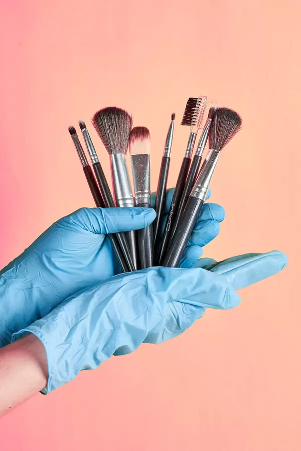 Set of make-up beauty brushes in beautician hands in gloves